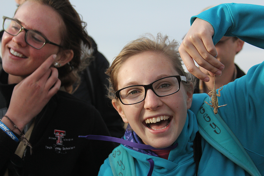 A student holding up a lizard.
