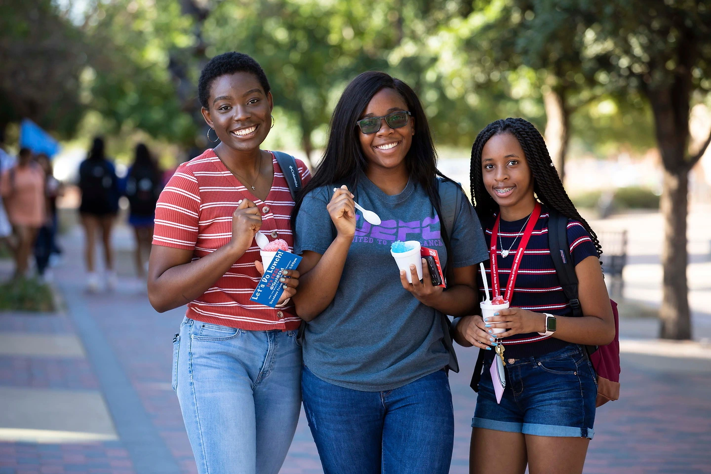 Three students on campus with snow cones.
