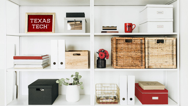 White shelves moderately filled with boxes and Texas Tech branded swag.