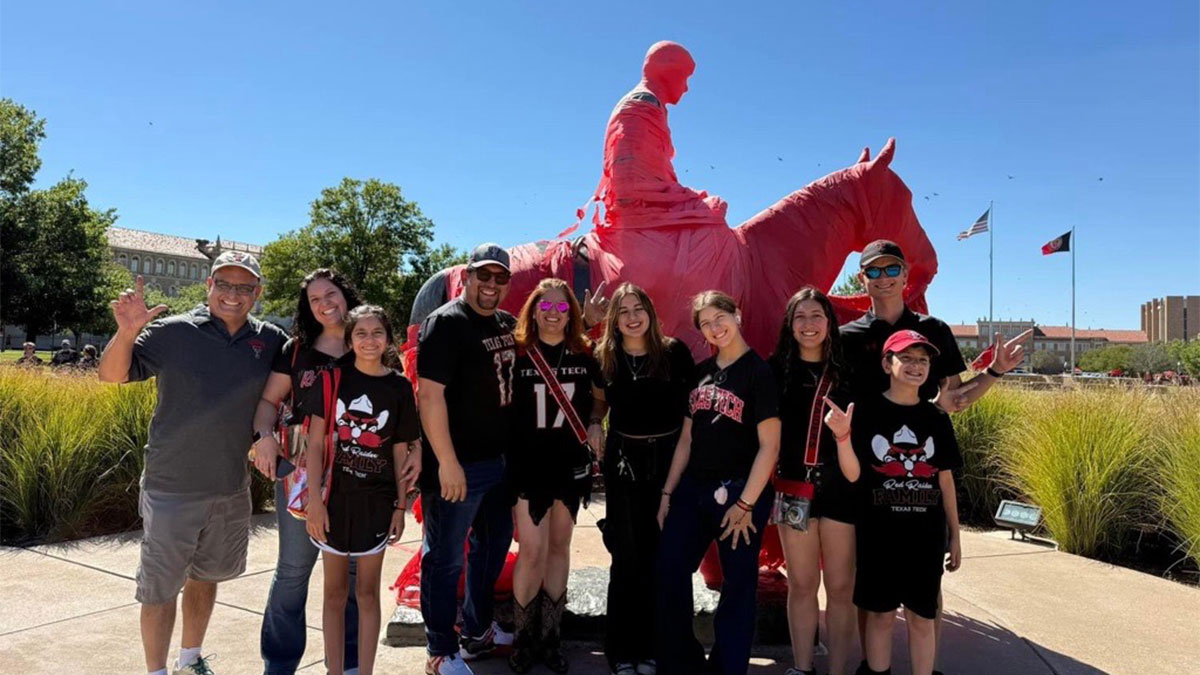 A group of students in front of the Will Rogers & Soapsuds statue.