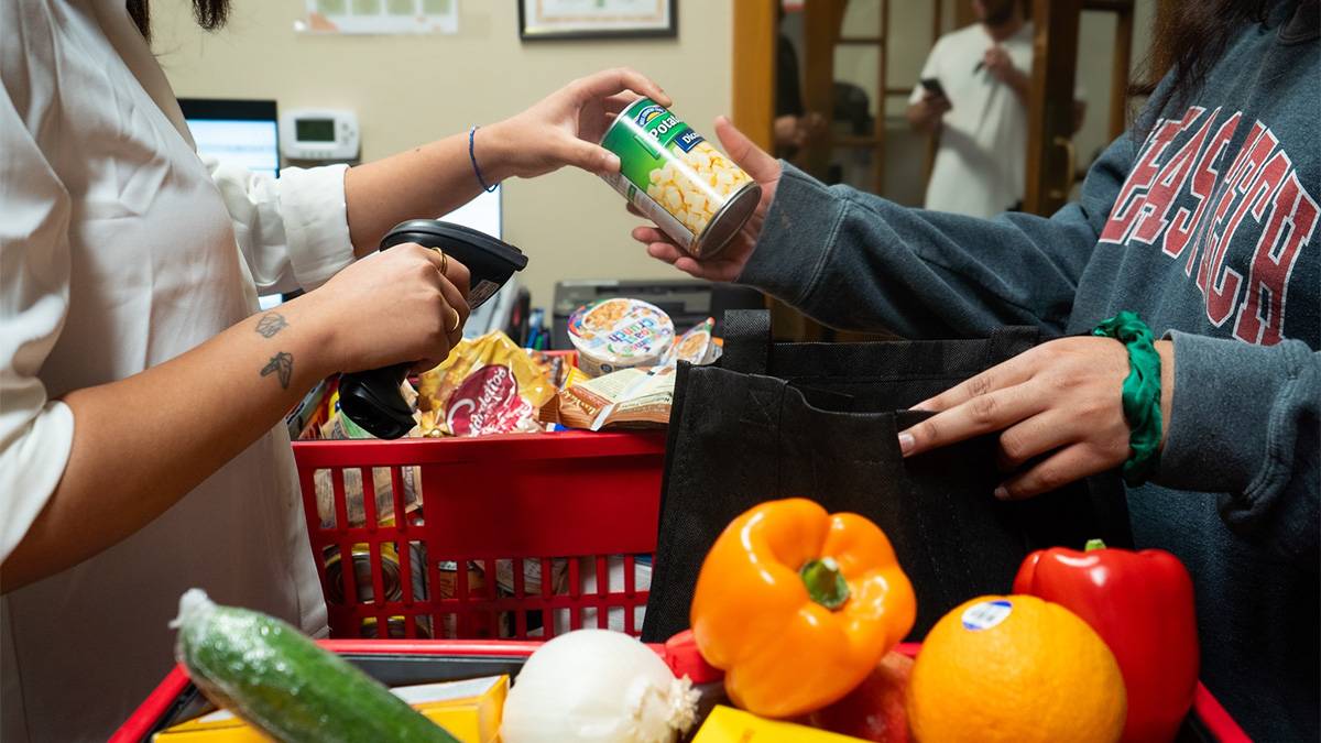 Student handing a canned good to another student.
