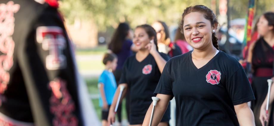 A marching band member smiles at camera.
