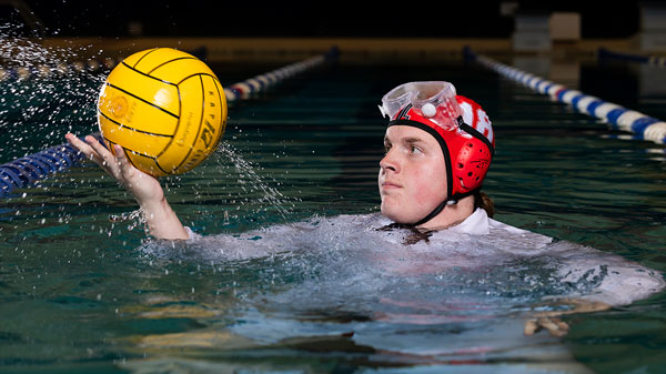Cavan Cox in swimming pool, balancing volleyball in his right palm