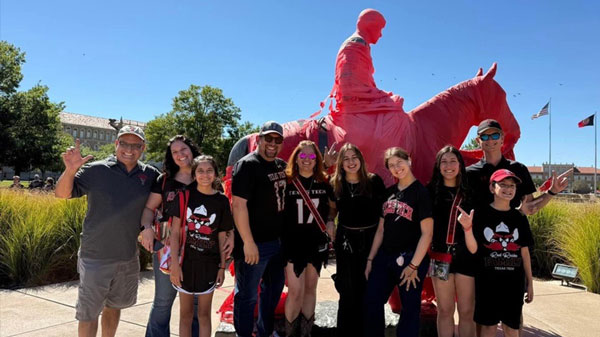 Family standing in front of Will Rogers statue