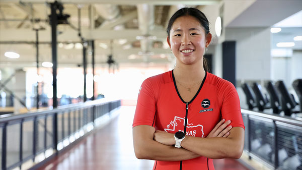 A female student stands with arms crossed at the Rec Center