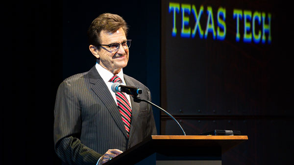 President Schovanec stands at podium in Maedgen Theatre
