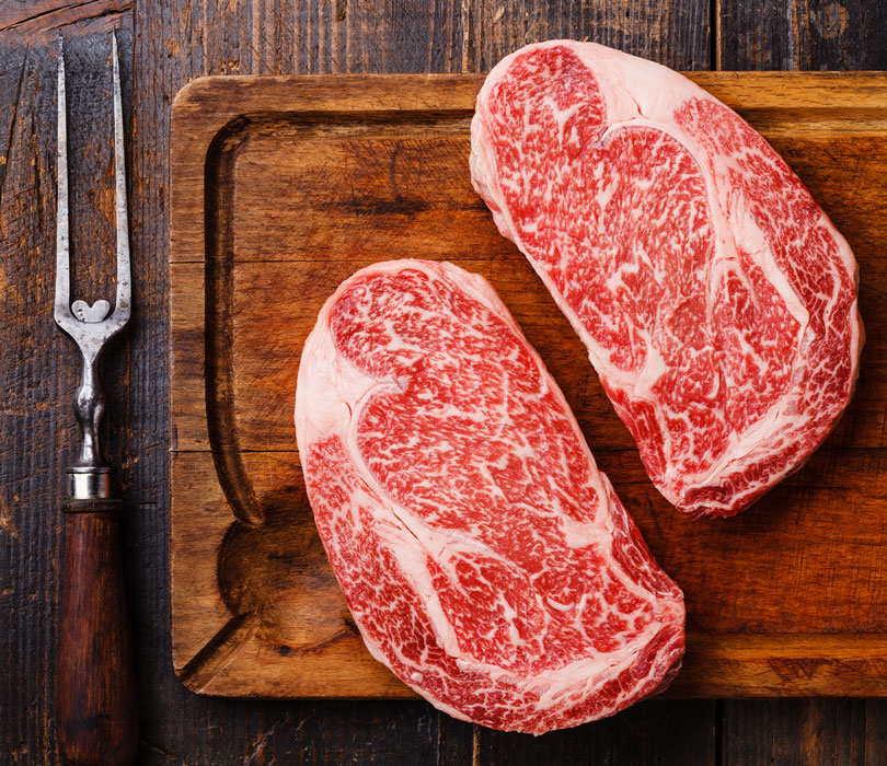 Steaks sitting on cutting board
