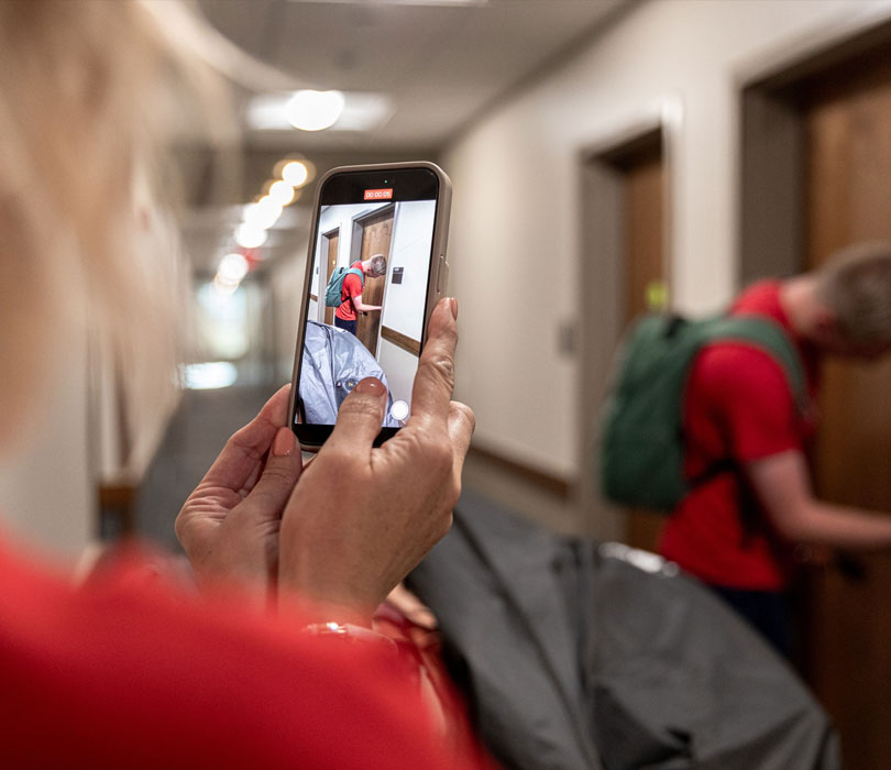 Mom taking picture of son unlocking dorm room