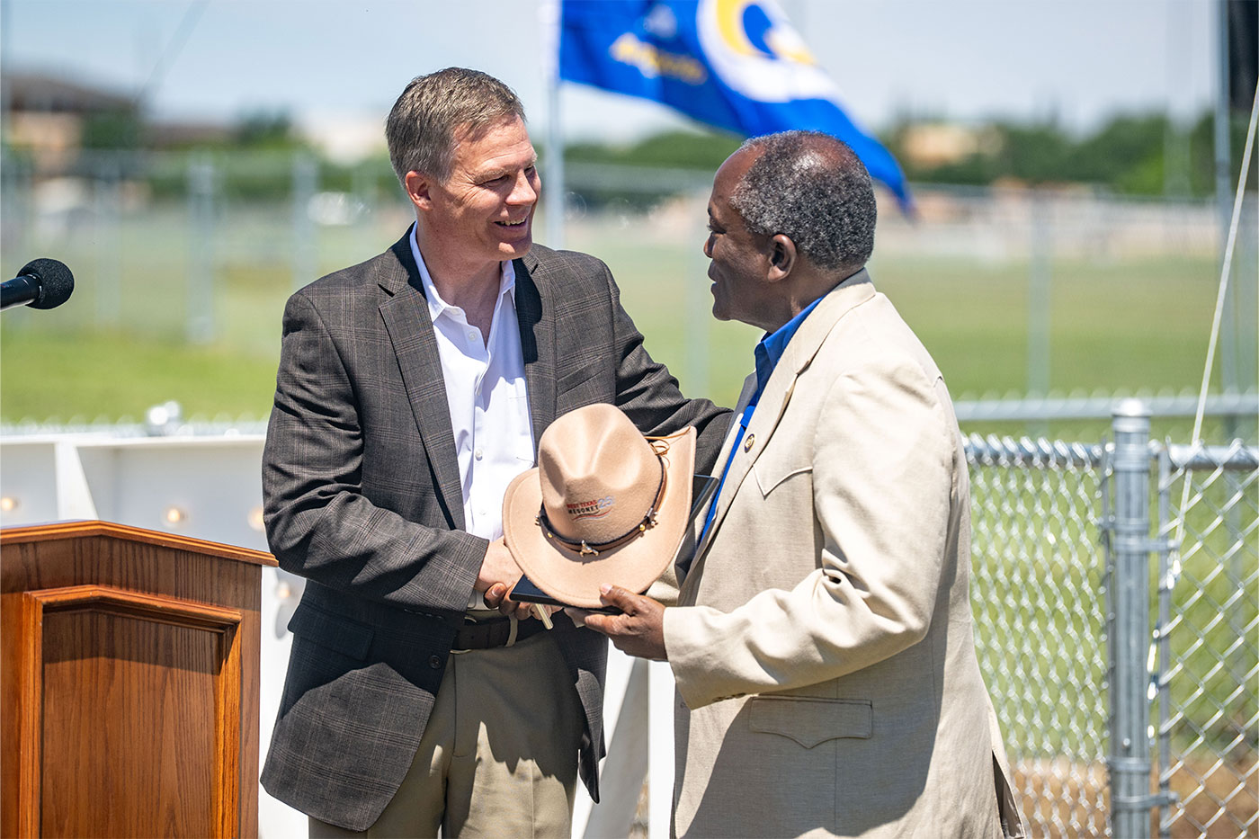 John Schroeder shakes hands with President Hawkins.