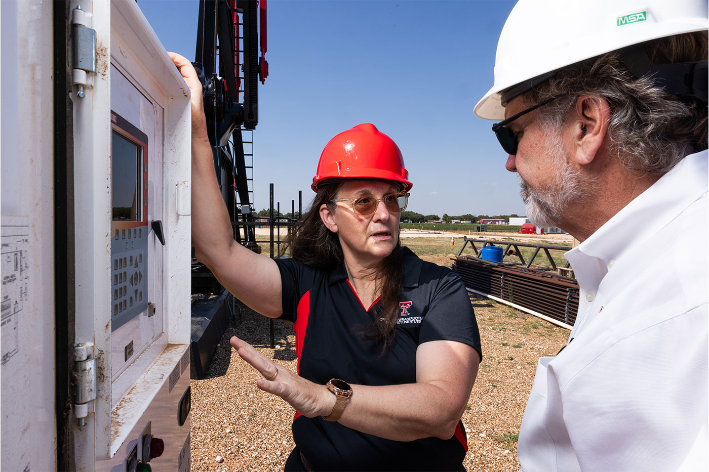Brenda Connor talking to a man at an industrial site. 