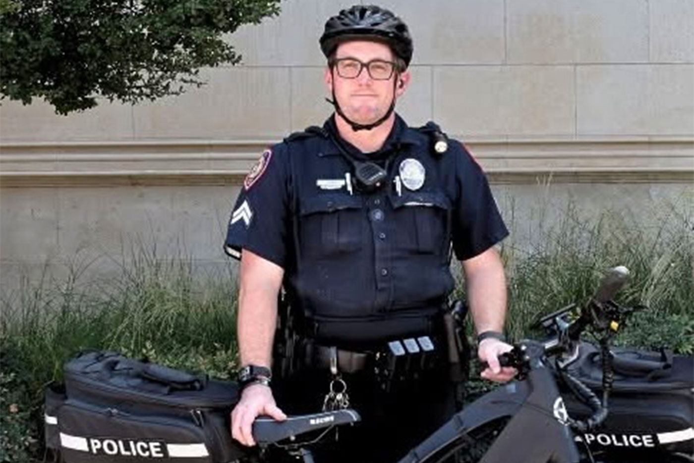 Jeff Bain in uniform next to his police bicycle