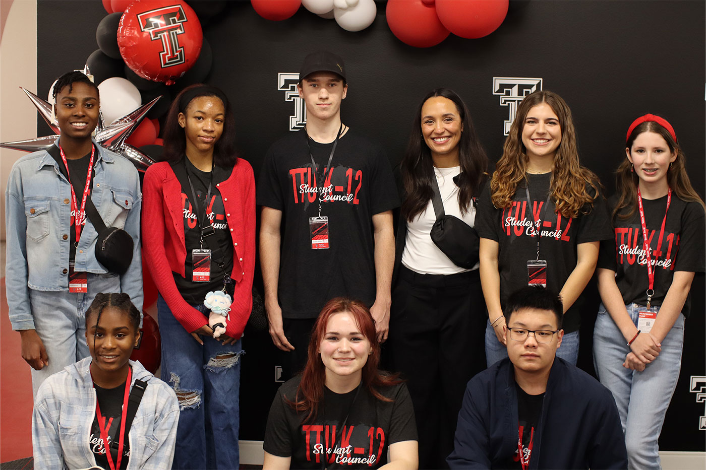 Adira, top left, and her sister Lael, bottom left, pose with student council at the 2025 Raiderpalooza.