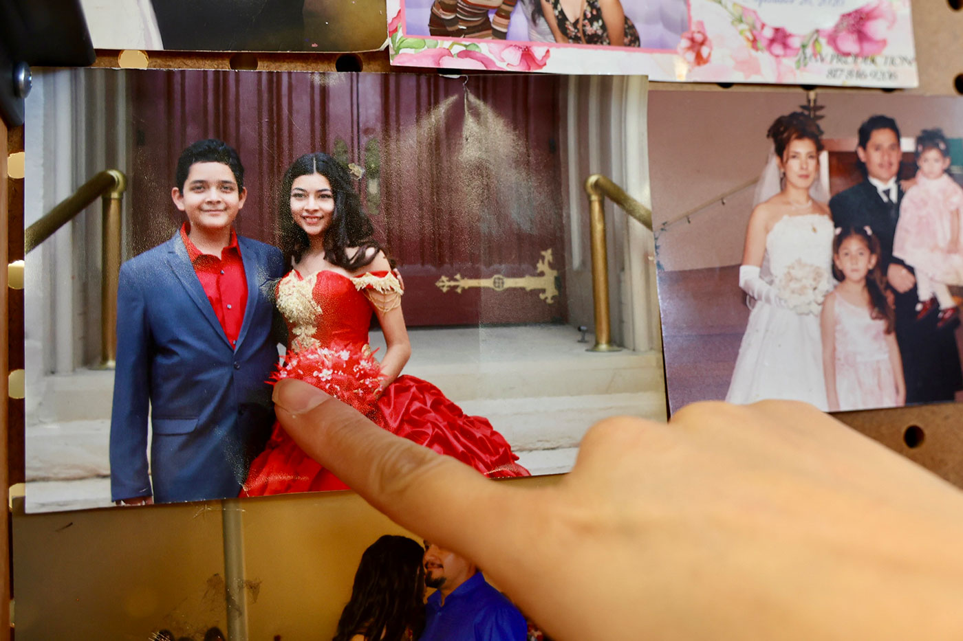 A hand pointing to a photo of Alex and Ruby as teenagers. 