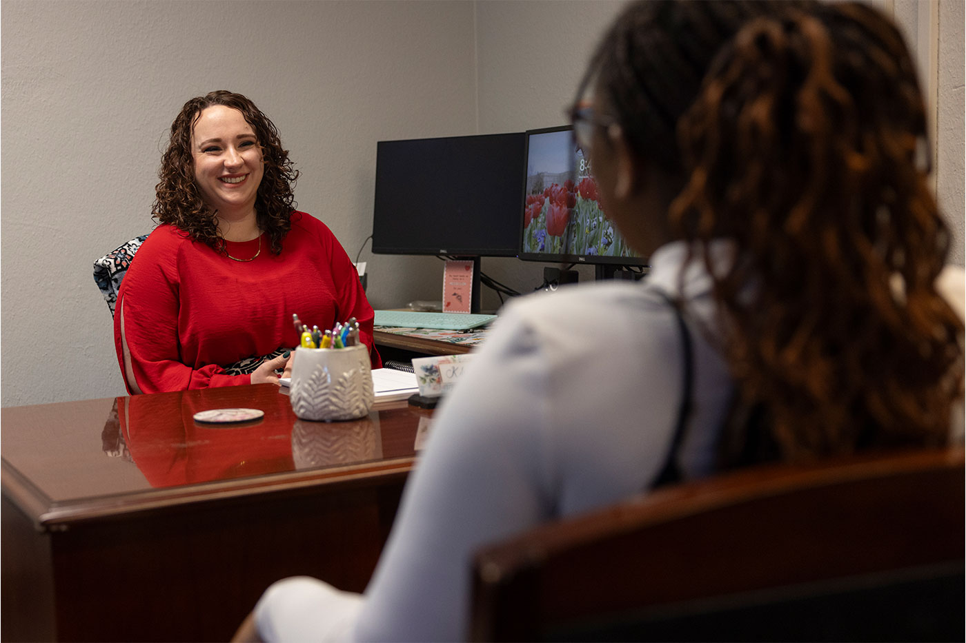 Kelsey Kimzey talking with a student across the desk. 