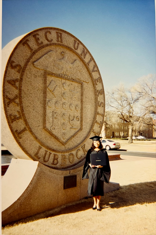 Victoria celebrating her graduation with the traditional photo at the Texas Tech seal.