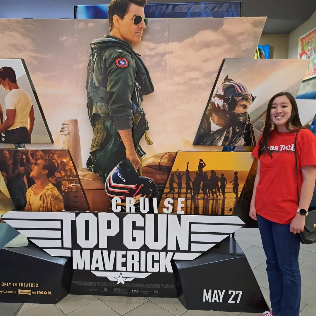 posing with top gun poster