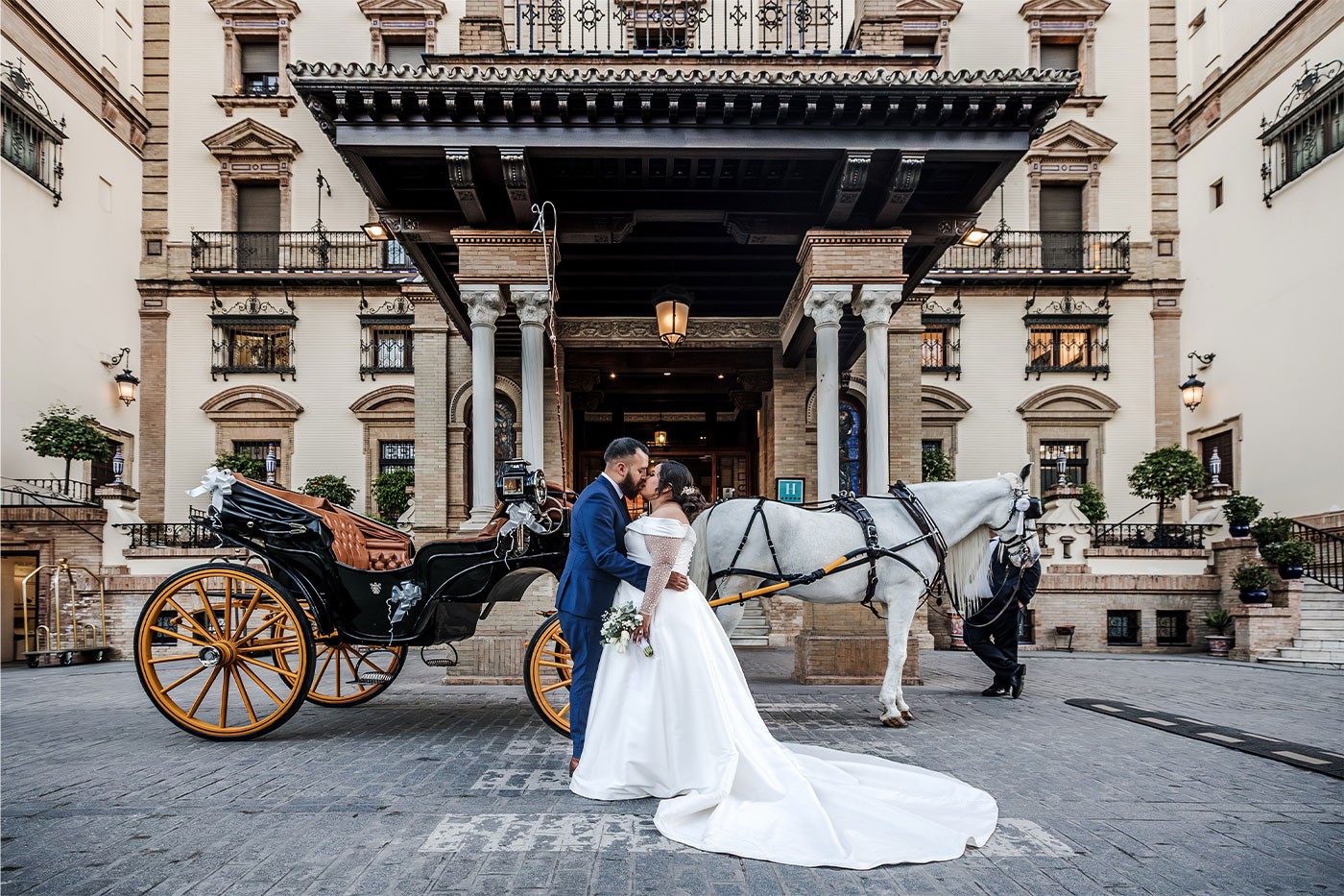 Norma and Frankie kiss in front of a carriage on their wedding day. 