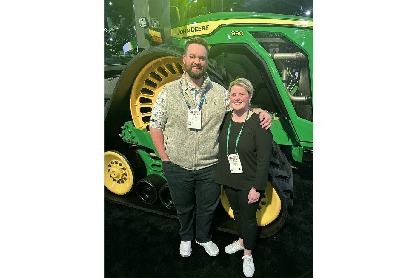 Kyle and Kirsten standing in front of a John Deere tractor