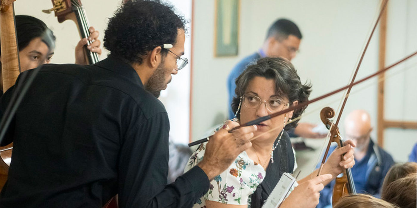 Conductor instructs violinist 