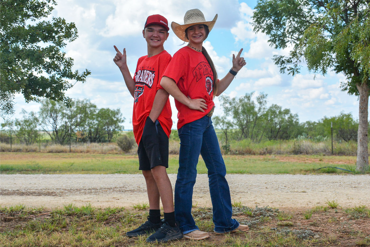 Twins back to back with their guns up. 