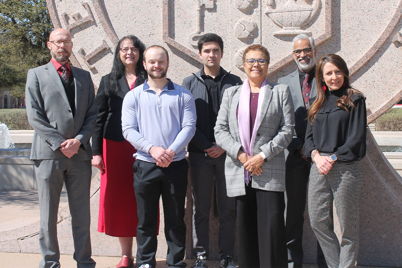 The researchers standing in front of the Texas Tech University seal. 