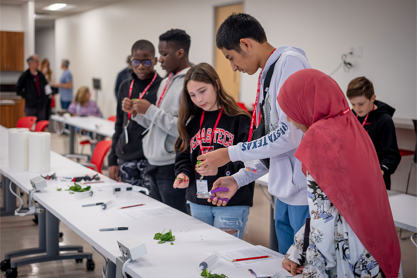 Students standing along a table 