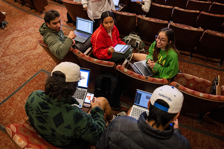 Students chatting while seated in a classroom.