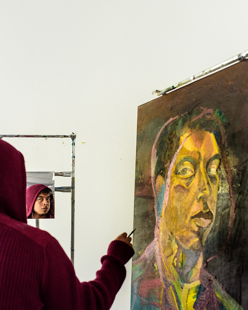 Student painting a self portrait.