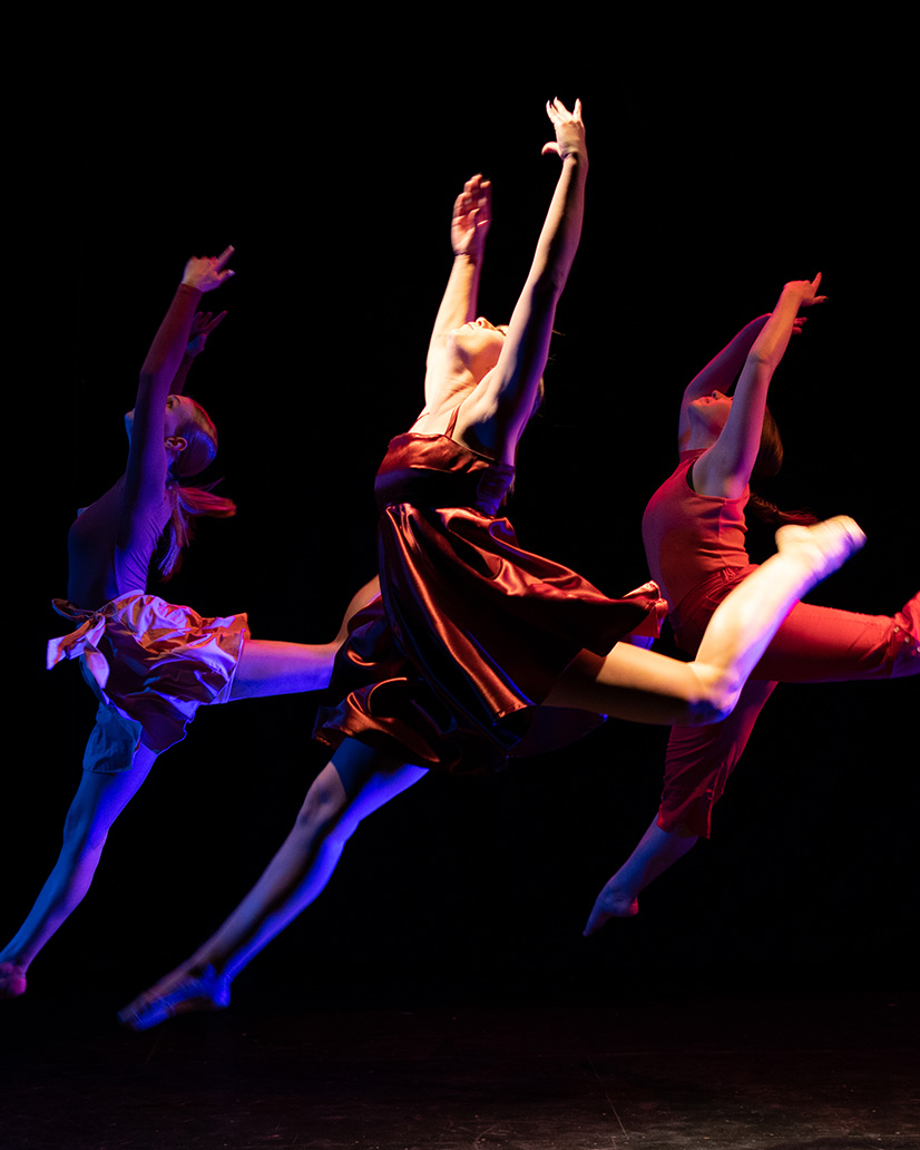 three students dancing in unison.