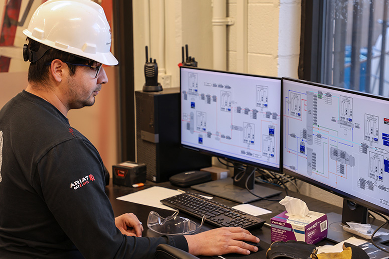 male with safety equipment working on computer