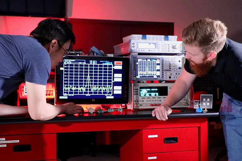 Students observe an oscilloscope.