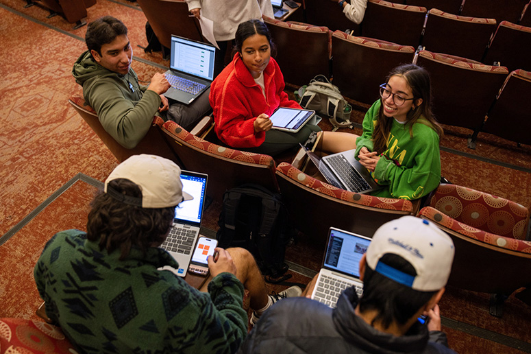 Group of students socializing in a classroom.