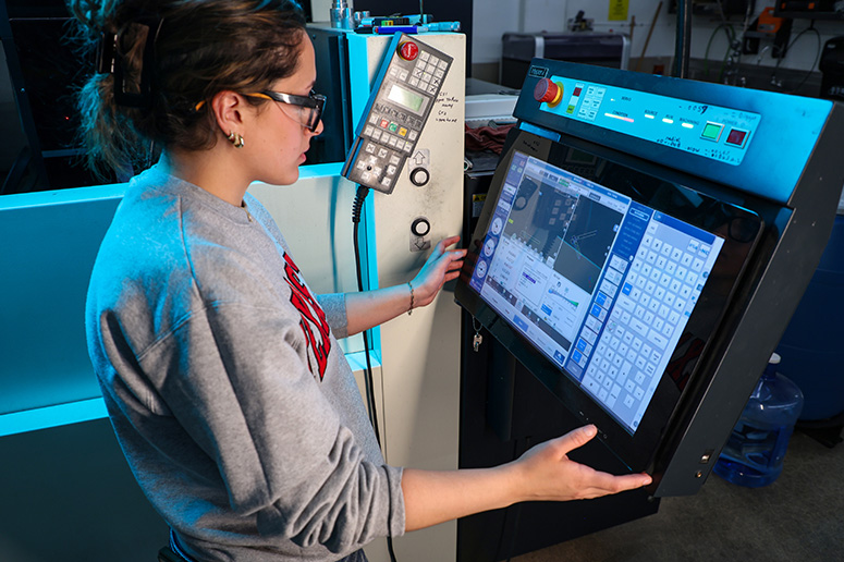 Student working on machining equipment.