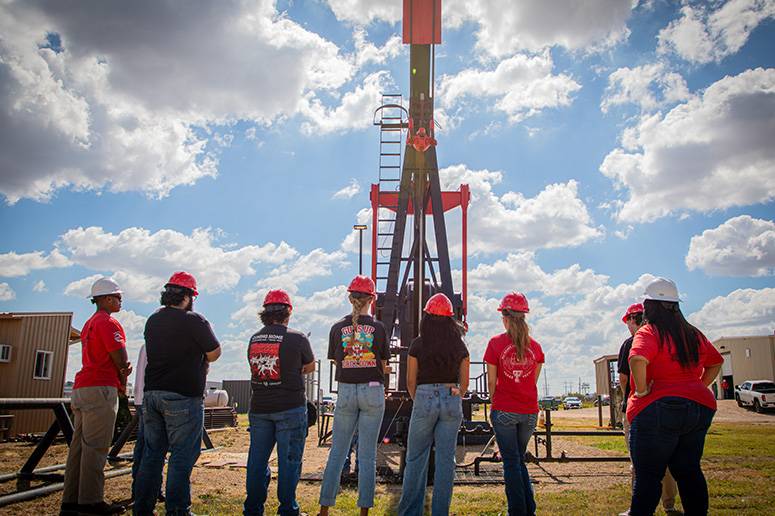 Students learning about a pumpjack from an instructor.