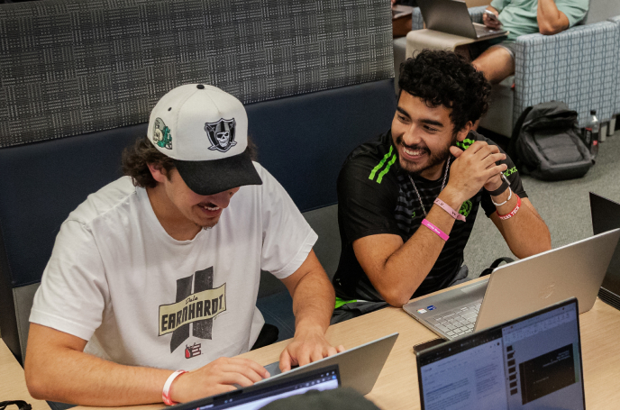 Three students examining and discussing.
